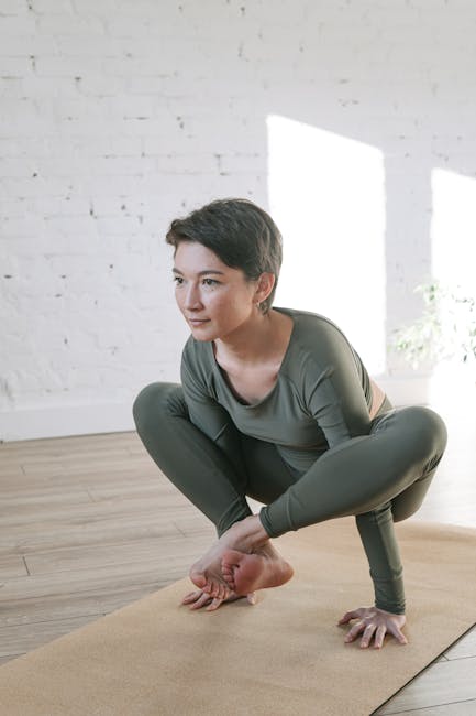 Woman performing a calm yoga pose in a brightly lit room.